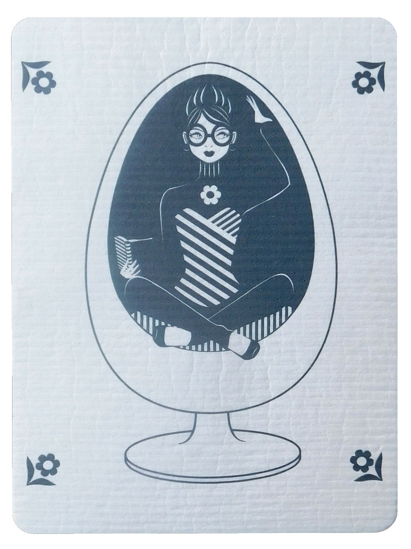 White Swedish dishcloth with grey graphic of a girl reading a book in an egg chair